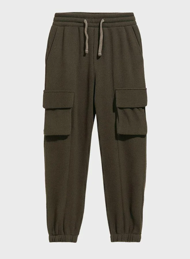 The Indian Garage Co  Men Loose Fit Solid Cargo Pocket Mid-Rise Joggers for Men | Best Price UAE